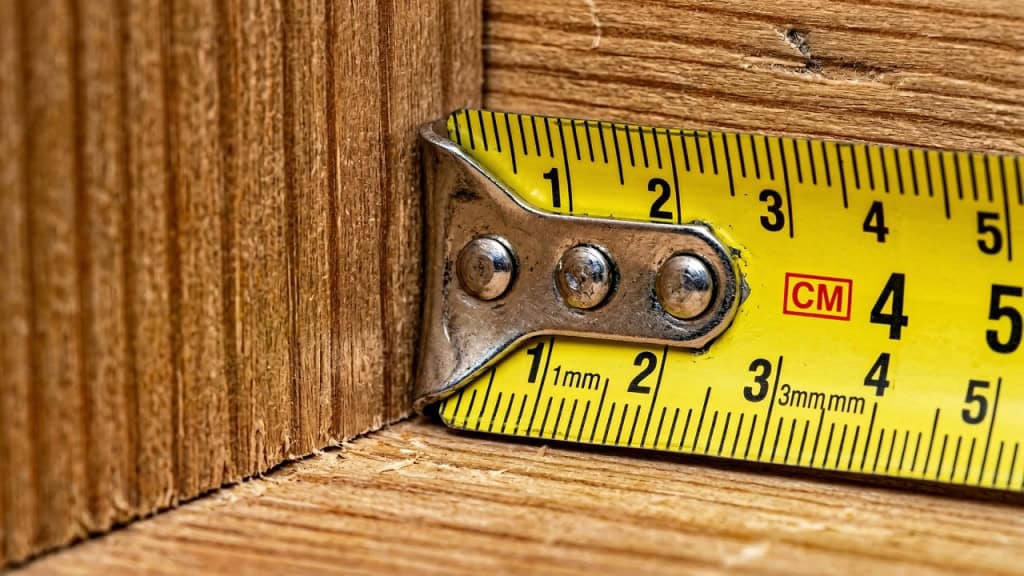 Para que serve a ponta metálica da fita métrica e por que ela se move?
